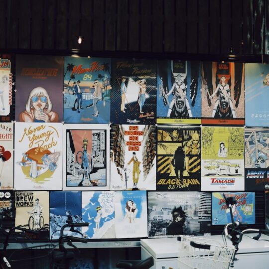Various posters displayed on a wall outside a shop