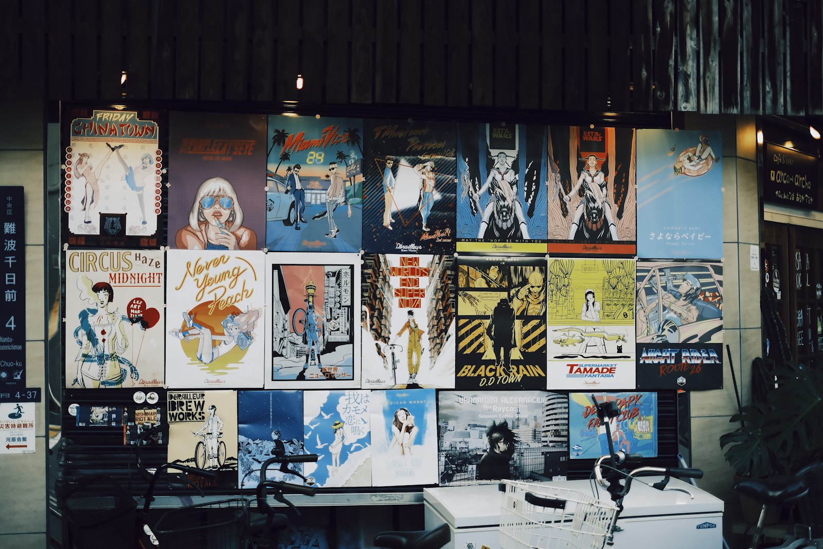 Various posters displayed on a wall outside a shop