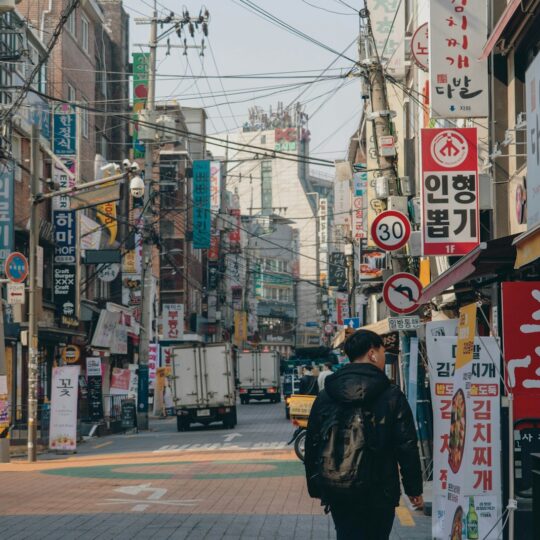 man in black jacket walking on sidewalk during daytime