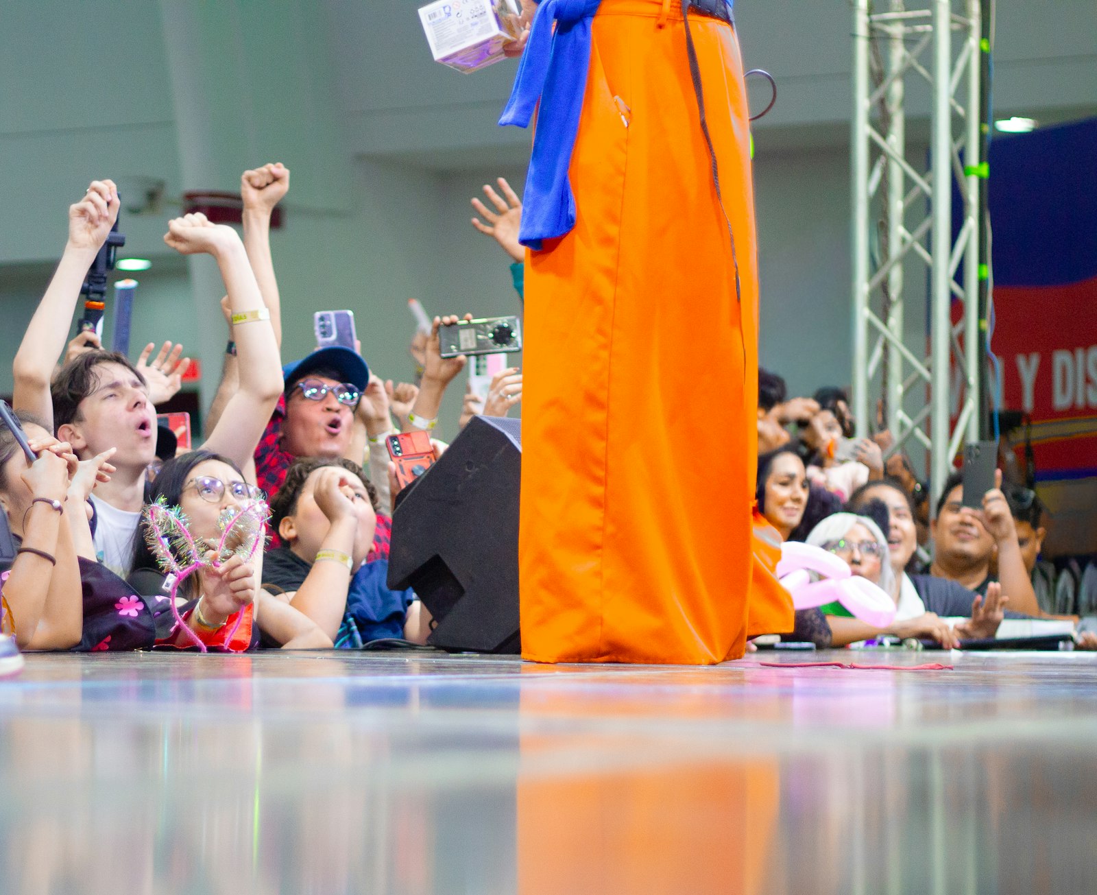 Crowd cheers for a person in orange costume