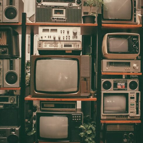 a wall of old televisions and old radio sets