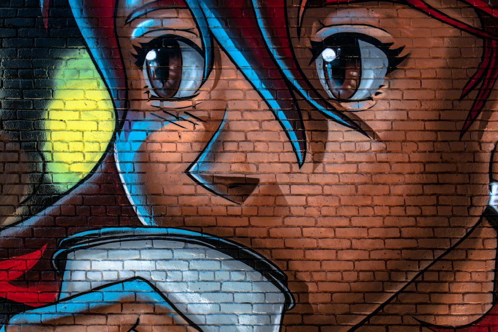 Anime style mural of a face painted on a red brick wall
